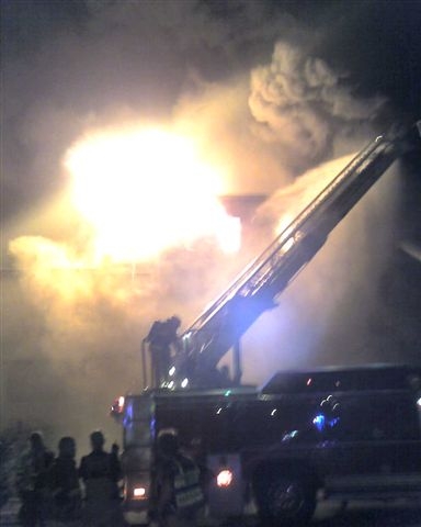 The building burns over fire fighters.